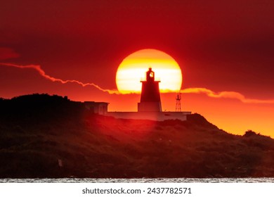 Lighthouse henge of golden sunset at Fugui Cape Park in northern eastern Taiwan. The henge is formed in every April and August under the circumstance that weather is good enough without low clouds. - Powered by Shutterstock