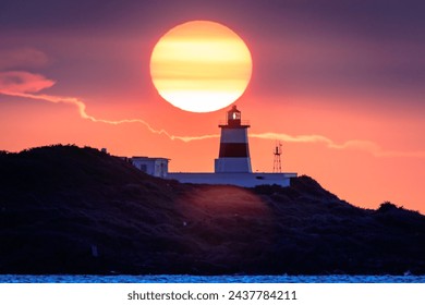 Lighthouse henge of golden sunset at Fugui Cape Park in northern eastern Taiwan. The henge is formed in every April and August under the circumstance that weather is good enough without low clouds. - Powered by Shutterstock