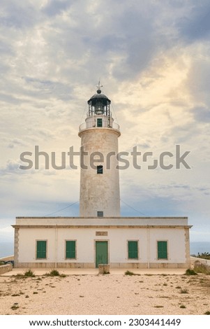 Lighthouse of La Mola, on the island of Formentera. Vertical photo on a cloudy day, with a clearing that lets in the sun's rays. Balearic Islands, Spain. Foto stock © 