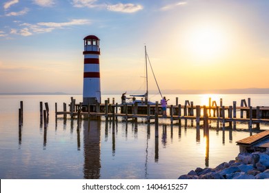 Lighthouse at Lake Neusiedl, Podersdorf am See, Burgenland, Austria. Lighthouse at sunset in Austria. Wooden pier with lighthouse in Podersdorf on lake Neusiedl in Austria.