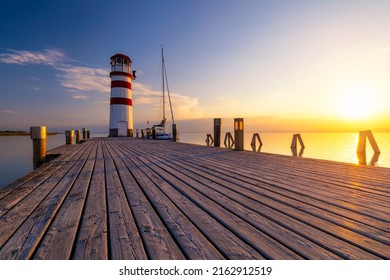 Lighthouse at Lake Neusiedl, Podersdorf am See, Burgenland, Austria. Lighthouse at sunset in Austria. Wooden pier with lighthouse in Podersdorf on lake Neusiedl in Austria.