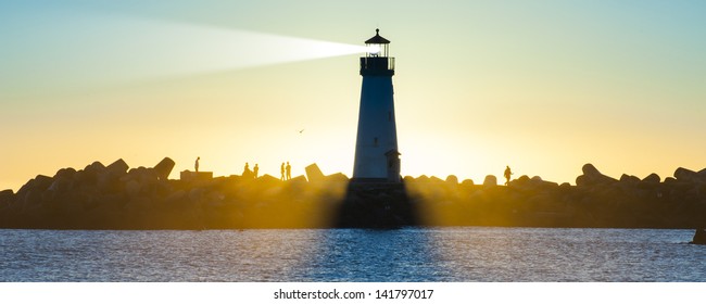 Lighthouse With Light Beam At Sunset