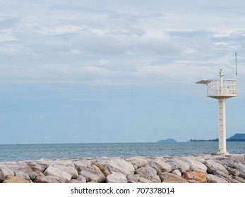 The lighthouse is located on the rocks.