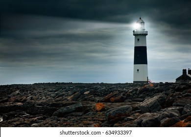 Lighthouse At Night With Spotlight Beam. Ireland