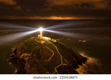 Lighthouse on coastal island with horizon at South Stack in Holyhead, North Wales. Lighthouse at sunset on the Isle of Anglesey - Powered by Shutterstock