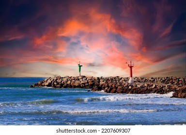 Lighthouse On Wave Breaker And Stone Pier At Sea. View Of The Mediterranean Sea With The Lighthouses At Rocky Shore. Wave Breakers Along The Shoreline With Lighthouse At Ocean. Lighthouse On Sunset.