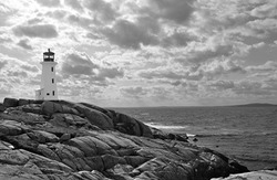 Lighthouse At Peggy's Cove, Nova Scotia.  In Black And White With Dramatic Clouds In Sky.