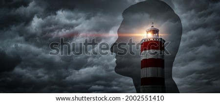 The lighthouse points the way against the background of a silhouette of a man Concept on the topic of psychology, psychiatry, self-development. Lighthouse symbolises the search for oneself.