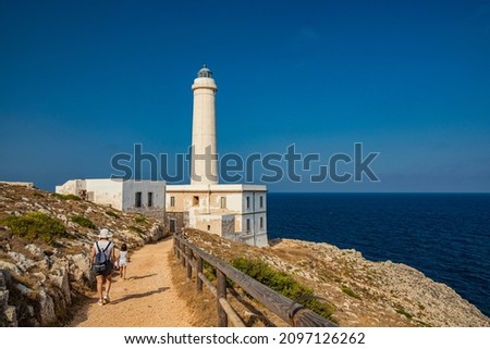 The lighthouse of Punta Palascia, in Otranto, Lecce, Salento, Puglia, Italy. The cape is Italy's most easterly point. A little girl with her mother walks along the path that leads to the lighthouse.