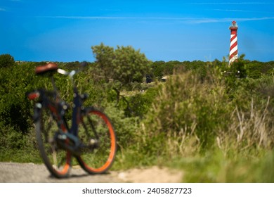 Lighthouse red white. Bicycle out of focus. Dutch landscape shot against blue sky. Holland, Zeeland, Haamstede. - Powered by Shutterstock