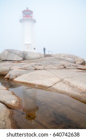 Lighthouse Reflection on Small Pool Of Water On Foggy Day