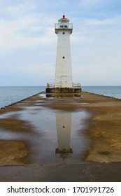 Lighthouse with reflection over puddle of water