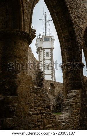 The lighthouse of Saint-Mathieu is framed by the weathered stone ruins of the former abbey church, creating a striking contrast between medieval remains and the coastal beacon on the rugged Breton coast.

