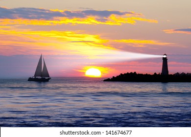 Lighthouse With Searchlight Beam At Sunset