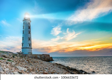 Lichtstrahl des Leuchtturms durch die Meeresluft nachts. Seascape bei Sonnenuntergang