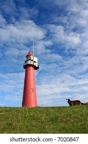 Lighthouse with sheep on dyke in Holland