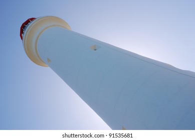 A lighthouse with sun behind