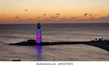 Lighthouse at sunset over the ocean, with a dramatic sky and calm water