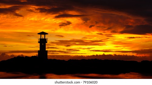 A lighthouse in the sunset sky