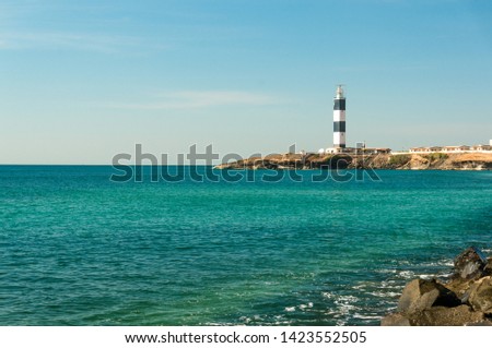 Lighthouse and wave breakers on the coast of the beautiful blue arabian sea in dwarka gujarat india. This highly religious and holy place is one of the most sacred places in hinduism. It also offers