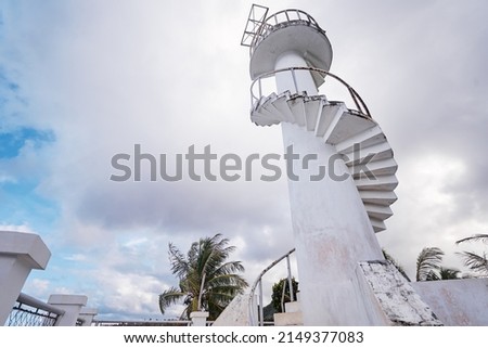 Lighthouse. White tower with stairs against sky.