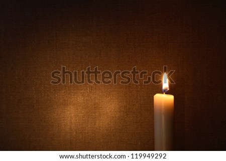Lighting candle against canvas background with free space for text