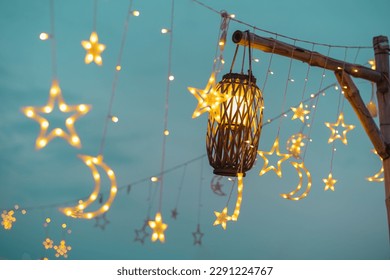 Lighting decor elements at a party outdoors. Cozy lights lanterns and light garland background. - Powered by Shutterstock