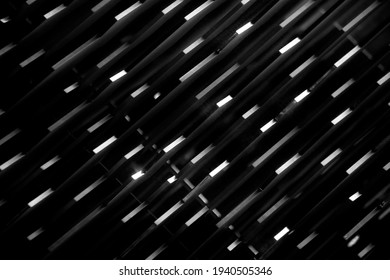 Lighting elements in slots between panels and tiles. Grunge background photo for industry, technology or abstract architecture with irregular geometric structure of short lines glowing in darkness.
