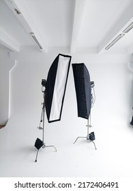 Lighting equipment on a cyclorama in modern photo studio. Two stripboxes on a c-stand on a clean white cyclorama background. Professional lighting equipment.