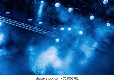 Lighting Equipment On The Stage Of The Theatre During The Performance. The Light Rays From The Spotlight Through The Smoke. Blue Rays Of Light.