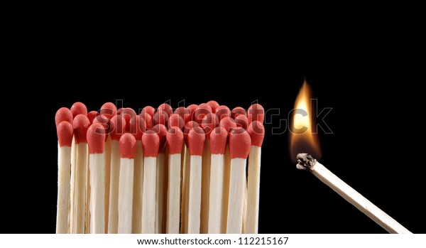 lighting\
matches on black background.Flaming\
matchsticks.