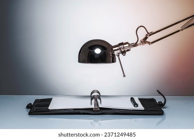 lighting up notebook diary writing with desk lamp on round studio lighting