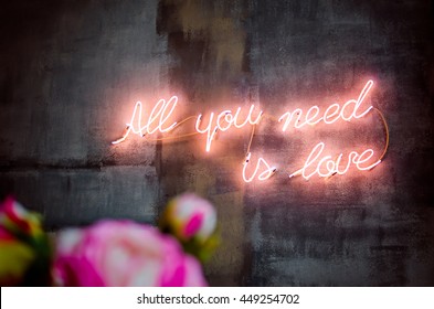 lighting words on the wall, all you need is love