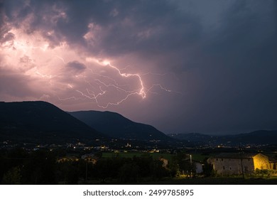 Lightning bolt above the mountains on the east side of Lake Garda, Italy - Powered by Shutterstock