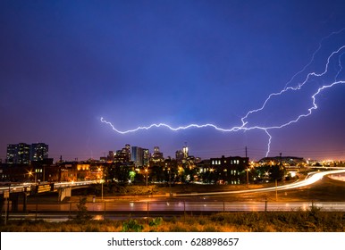 Lightning Bolt Strikes Above The Downtown City Skyline Of Denver, Colorado During A Powerful Summer Storm