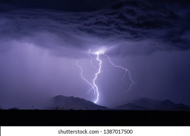 A lightning bolt strikes a mountain during a thunderstorm