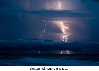 Lightning Rays Strikes and Thunder Over the Ocean in Dark Sky