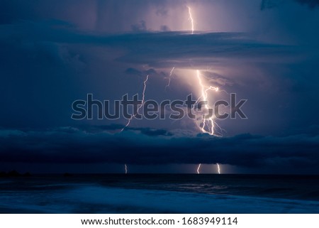 Lightning Rays Strikes and Thunder Over the Ocean in Dark Sky