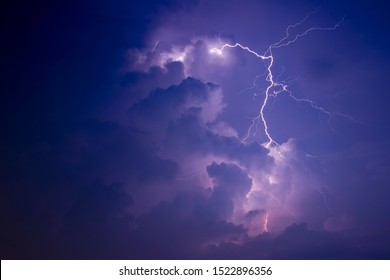 Lightning streaks lights up clouds in the middle of the night.Night scene.