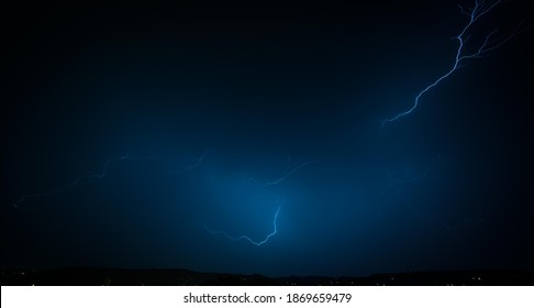 Lightning Strike On A Dark Blue Sky. Bolt Of Light Cutting Night Sky