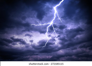 Lightning strike on the dark cloudy sky - Shutterstock ID 272185115