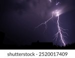 Lightning strikes across the sky on a summer night during a thunderstorm