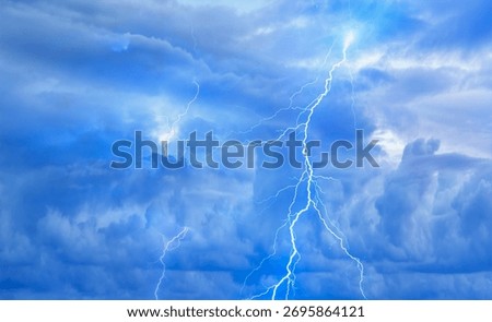 Lightning strikes between stormy clouds.