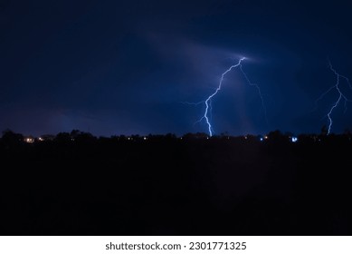 Lightning strikes the horizon before a rain storm in a suburban field in Nakhon Sawan province, Thailand.