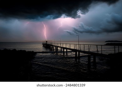 Lightning striking old metal pier, dramatic seaside landscape photo - Powered by Shutterstock