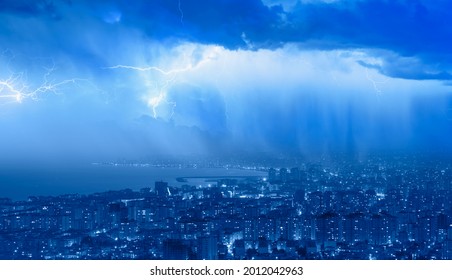 Lightning thunderstorm flash over the city at blue night sky - Lightning storm over city in blue light - Powered by Shutterstock