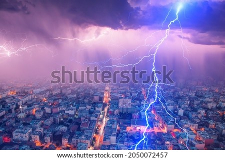 Lightning thunderstorm flash over the city at night sky - Lightning storm over city with rain