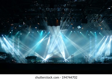 Lights beams on stage with piano and musical instruments