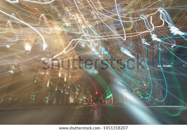 The lights of blurred curved fast motion at the\
highway. Long exposure of urban abstract night traffic. Beautiful\
illumination of city during night. Light trails. Words on the\
building Al Coro.