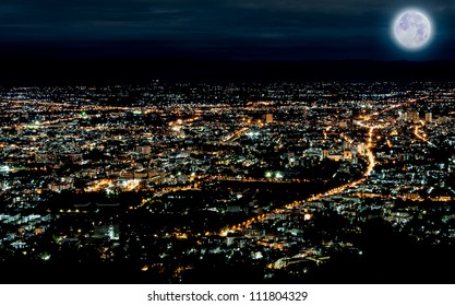 Lights Of City In Night Time Scene With Blue Moon In Chiang Mai Of Thailand